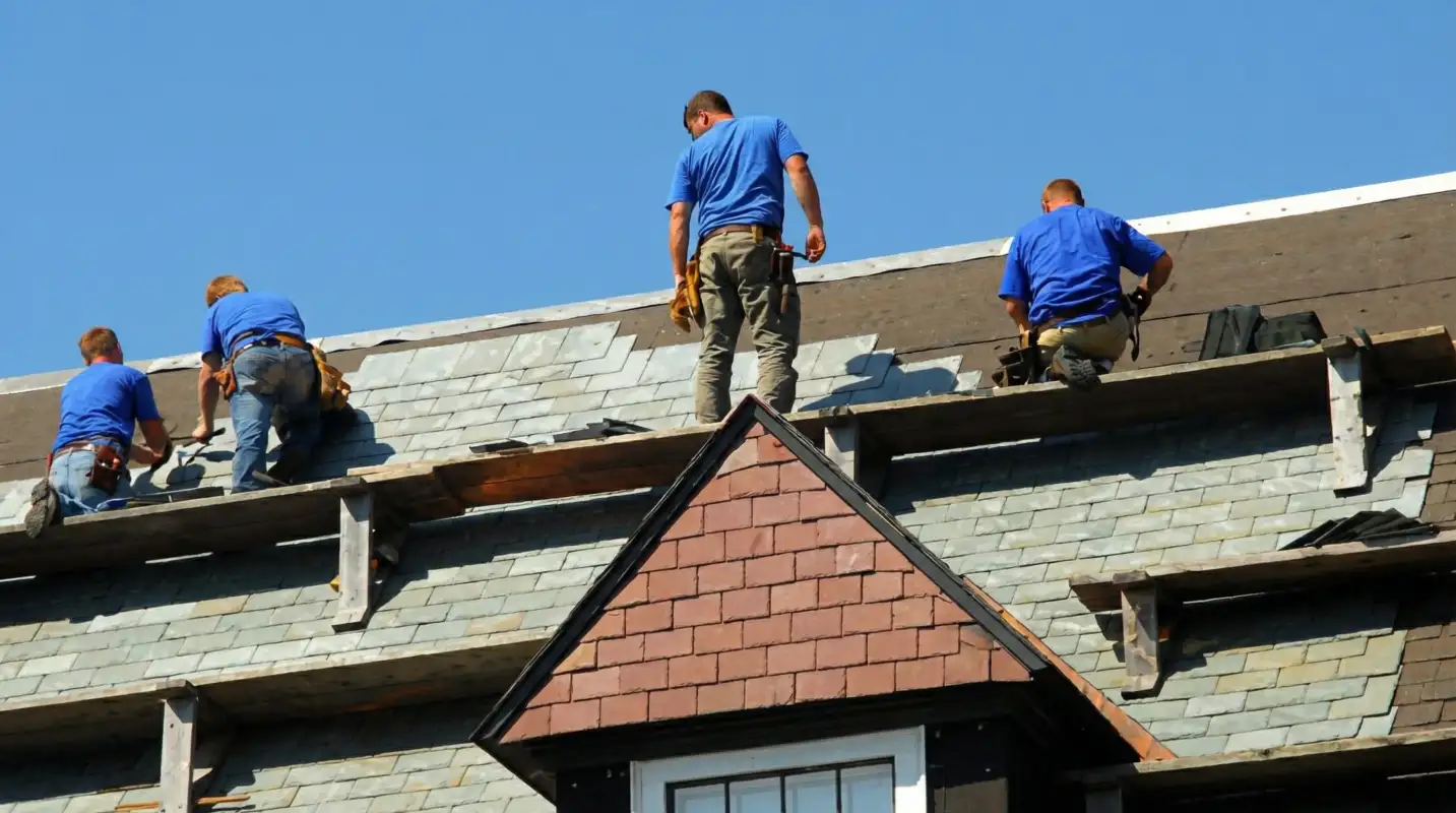 Roof replacement in progress with a team of professional contractors installing new shingles on a residential home in New Haven, CT